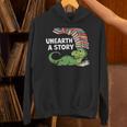 Summer Reading 2026 Unearth a Story Theme Dinosaur Book Nerd Unisex Hoodie Summer Reading 2026 Unearth a Story Theme Dinosaur Book Nerd Unisex Hoodie