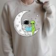 Astronaut And Alien Reading On Moon Space Book Lover Sci Fi Raglan Sleeve Sweatshirt Heather Forest