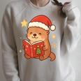 Cute Christmas Book Otter Reading Snowy Holiday Story Raglan Sleeve Sweatshirt Heather Forest