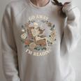 Go Away I'm Reading Librarian Skeleton Reading Book Lover Raglan Sleeve Sweatshirt Heather Forest