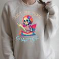 Just One More Chapter Skeleton Reading Book Nerd Quote Raglan Sleeve Sweatshirt Heather Forest