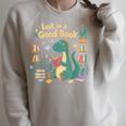 Lost In a Good Book Cute Reading Dinosaur Illustration Raglan Sleeve Sweatshirt Heather Forest