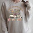 A New Chapter Begins Retirement Floral Book Retired 2026 Raglan Sleeve Sweatshirt Heather Forest A New Chapter Begins Retirement Floral Book Retired 2026 Raglan Sleeve Sweatshirt Heather Forest
