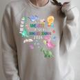 Unearth a Story Dinosaur Book 2026 Summer Reading Program Raglan Sleeve Sweatshirt Heather Forest Unearth a Story Dinosaur Book 2026 Summer Reading Program Raglan Sleeve Sweatshirt Heather Forest