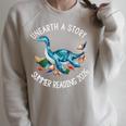 Unearth A Story Summer Reading 2026 Cute Plesiosaurus Book Raglan Sleeve Sweatshirt Heather Forest