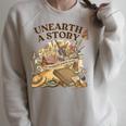 Unearth A Story Summer Reading 2026 Flower Butterfly Book Raglan Sleeve Sweatshirt Heather Forest Unearth A Story Summer Reading 2026 Flower Butterfly Book Raglan Sleeve Sweatshirt Heather Forest