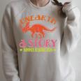 Unearth a Story Summer Reading 2026 Triceratops Dino Book Raglan Sleeve Sweatshirt Heather Forest Unearth a Story Summer Reading 2026 Triceratops Dino Book Raglan Sleeve Sweatshirt Heather Forest