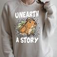 Unearth A Story Summer Reading Program 2026 Capybara Book Raglan Sleeve Sweatshirt Heather Forest
