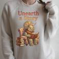 Unearth a Story Triceratops Dinosaur Reading Books Dino Raglan Sleeve Sweatshirt Heather Forest Unearth a Story Triceratops Dinosaur Reading Books Dino Raglan Sleeve Sweatshirt Heather Forest