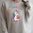 Unicorn Reading a Book Unearth a Story Program 2026 Raglan Sleeve Sweatshirt Heather Forest