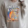 Women's Unearth A Story Rainbow Treasure Book Summer Reading 2026 Raglan Sleeve Sweatshirt Heather Forest Women's Unearth A Story Rainbow Treasure Book Summer Reading 2026 Raglan Sleeve Sweatshirt Heather Forest
