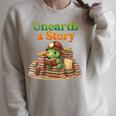 Women's Unearth a Story Summer 2026 Dinosaur Reading Books Dino Raglan Sleeve Sweatshirt Heather Forest Women's Unearth a Story Summer 2026 Dinosaur Reading Books Dino Raglan Sleeve Sweatshirt Heather Forest