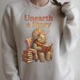 Women's Unearth a Story Triceratops Dinosaur Reading Books Dino Raglan Sleeve Sweatshirt Heather Forest