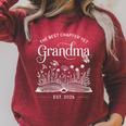 The Best Chapter Yet Grandma Est 2026 Book Lover Floral Raglan Sleeve Sweatshirt Heather Dust