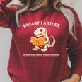 Dinosaur Books Readers Summer Reading 2026 Unearth a Story Raglan Sleeve Sweatshirt Heather Dust