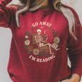 Go Away I'm Reading Librarian Skeleton Reading Book Lover Raglan Sleeve Sweatshirt Heather Dust