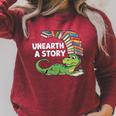 Summer Reading 2026 Unearth a Story Theme Dinosaur Book Nerd Raglan Sleeve Sweatshirt Heather Dust