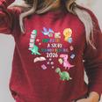Unearth a Story Dinosaur Book 2026 Summer Reading Program Raglan Sleeve Sweatshirt Heather Dust Unearth a Story Dinosaur Book 2026 Summer Reading Program Raglan Sleeve Sweatshirt Heather Dust