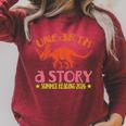 Unearth a Story Summer Reading 2026 Triceratops Dino Book Raglan Sleeve Sweatshirt Heather Dust Unearth a Story Summer Reading 2026 Triceratops Dino Book Raglan Sleeve Sweatshirt Heather Dust