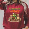 Women's Unearth a Story Summer 2026 Dinosaur Reading Books Dino Raglan Sleeve Sweatshirt Heather Dust Women's Unearth a Story Summer 2026 Dinosaur Reading Books Dino Raglan Sleeve Sweatshirt Heather Dust