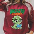Women's Unearth a Story Summer Reading 2026 Triceratops Dino Book Raglan Sleeve Sweatshirt Heather Dust Women's Unearth a Story Summer Reading 2026 Triceratops Dino Book Raglan Sleeve Sweatshirt Heather Dust
