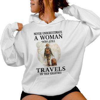 Never Underestimate A Woman Who Still Travels In Her 80'S Women Hoodie - Thegiftio UK