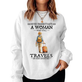 Never Underestimate A Woman Who Still Travels In Her Eightie Women Sweatshirt - Thegiftio UK