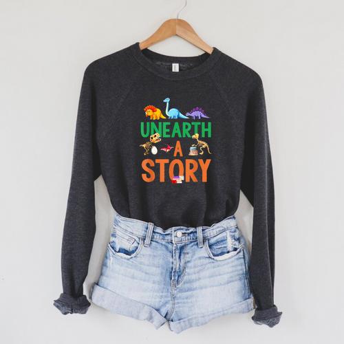 Summer Reading 2026 Dinosaurs Book Lover Unearth A Story Raglan Sleeve Sweatshirt - Bookorys