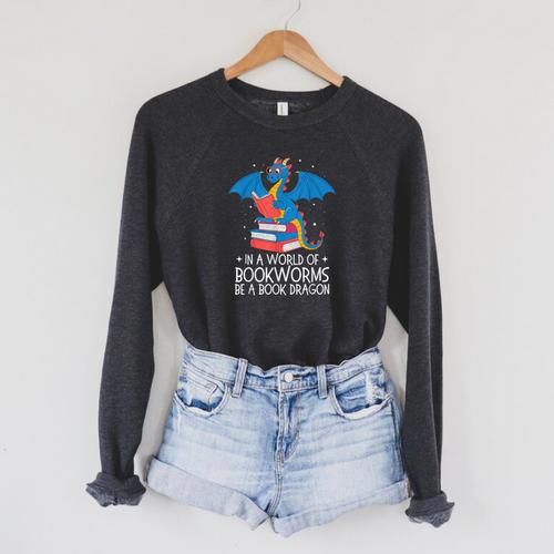 In A World Full Of Bookworms Be A Book Dragon Reading Raglan Sleeve Sweatshirt - Bookorys CA