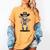 Cowboy Skeleton Baseball Halloween Graphic Women's Comfort Colors T-Shirt Mustard Cowboy Skeleton Baseball Halloween Graphic Women's Comfort Colors T-Shirt Mustard