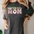 Baseball Mom Bleached Messy Bun Game Day Women's Comfort Colors T-Shirt Pepper Baseball Mom Bleached Messy Bun Game Day Women's Comfort Colors T-Shirt Pepper