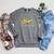 Unearth a Story Dinosaur 2026 Summer Reading Program Book Raglan Sleeve Sweatshirt Deep Heather Unearth a Story Dinosaur 2026 Summer Reading Program Book Raglan Sleeve Sweatshirt Deep Heather