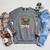 Women's Unearth A Story Summer Reading 2026 Dinosaur Book Floral Raglan Sleeve Sweatshirt Deep Heather Women's Unearth A Story Summer Reading 2026 Dinosaur Book Floral Raglan Sleeve Sweatshirt Deep Heather