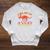 Unearth a Story Summer Reading 2026 Triceratops Dino Book Raglan Sleeve Sweatshirt Heather Mustard
