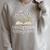 A New Chapter Begins Retired 2026 Floral Book Retirement Raglan Sleeve Sweatshirt Heather Forest