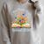 New Chapter Begins Retired 2026 Watercolor Floral Book Women Premium Tri-Blend Raglan Sleeve Sweatshirt Heather Forest