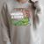 Summer Reading 2026 Unearth a Story Theme Dinosaur Book Nerd Raglan Sleeve Sweatshirt Heather Forest