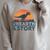 Unearth A Story Dinosaur Reader Book Lover 2026 Raglan Sleeve Sweatshirt Heather Forest