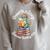 Unearth a Story Summer Reading 2026 Book Lover Dino Fun Raglan Sleeve Sweatshirt Heather Forest
