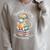 Unearth A Story Summer Reading 2026 Cute Dino Book Lover Raglan Sleeve Sweatshirt Heather Forest