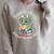 Unearth a Story Summer Reading 2026 Cute Dinosaur Book Lover Raglan Sleeve Sweatshirt Heather Forest