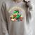 Unearth A Story Summer Reading 2026 Dinosaur Book Floral Raglan Sleeve Sweatshirt Heather Forest Unearth A Story Summer Reading 2026 Dinosaur Book Floral Raglan Sleeve Sweatshirt Heather Forest