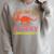 Unearth a Story Summer Reading 2026 Triceratops Dino Book Premium Tri-Blend Raglan Sleeve Sweatshirt Heather Forest