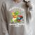 Unearth a Story Triceratops Dinosaur Reading Books Cute Dino Premium Tri-Blend Raglan Sleeve Sweatshirt Heather Forest