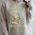 Women's Unearth a Story Triceratops Dinosaur Reading Books Cute Dino Raglan Sleeve Sweatshirt Heather Forest