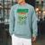 Women's Unearth a Story Summer Reading 2026 Triceratops Dino Book Raglan Sleeve Sweatshirt Cardinal