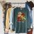 Unearth a Story Dinosaur Reading Book Dino T Rex Summer 2026 Raglan Sleeve Sweatshirt Heather Blue Lagoon