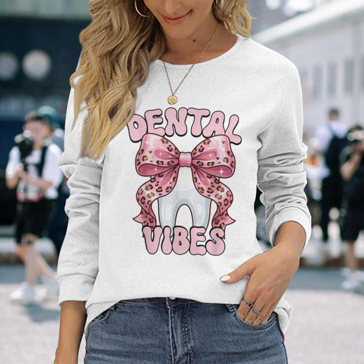 Dentalibes 歯 ピンク ヒョウ柄 弓 歯科医 長袖Tシャツ 彼女への贈り物