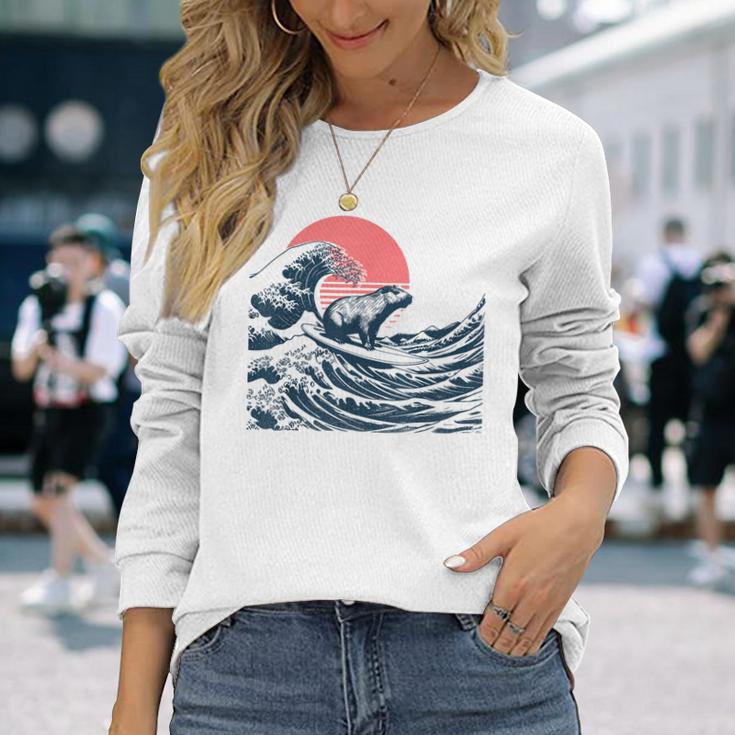 神奈川沖のビッグウェーブでサーフィンをするサーファーのカピバラ 長袖Tシャツ 彼女への贈り物