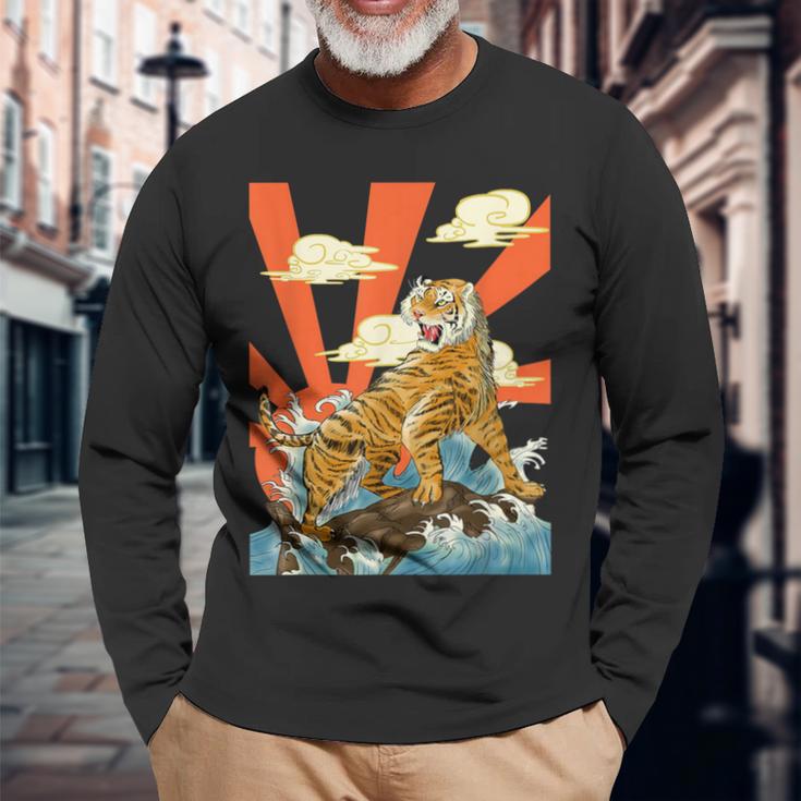 朝日を背景に、波の上を轟かせる雄大な虎。 長袖Tシャツ 高齢者への贈り物